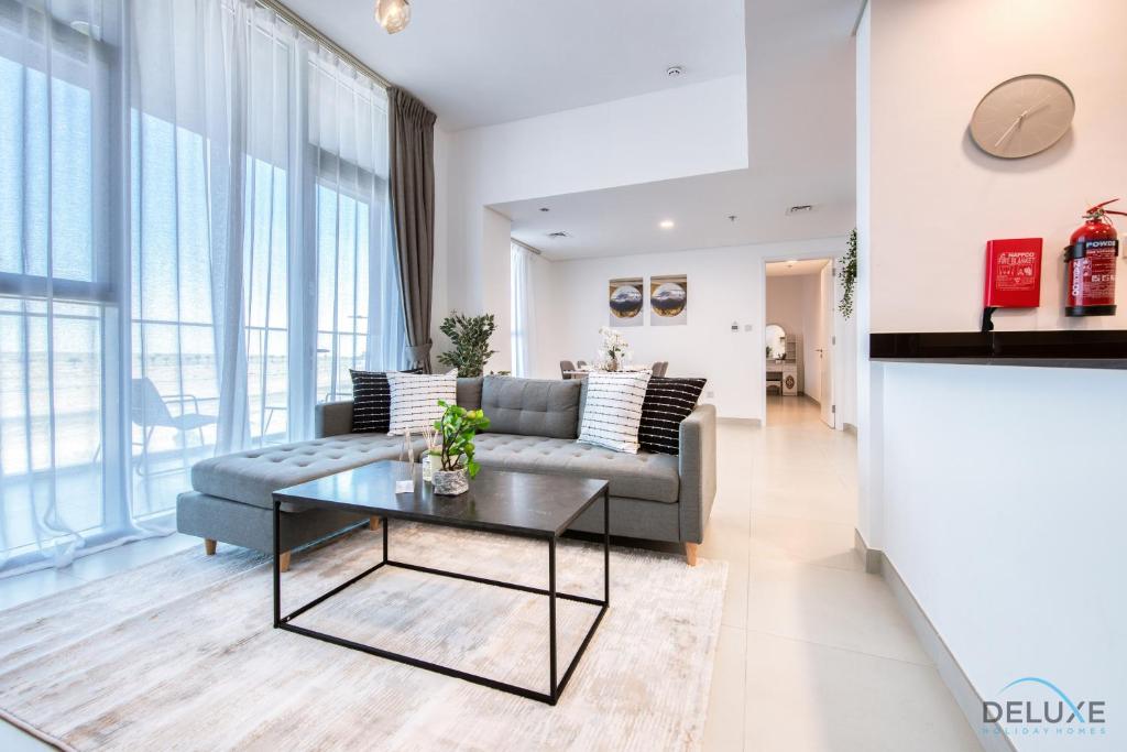 a living room with a couch and a table at Ideal 1BR at The Pulse Residence Icon A1 Dubai South by Deluxe Holiday Homes in Dubai