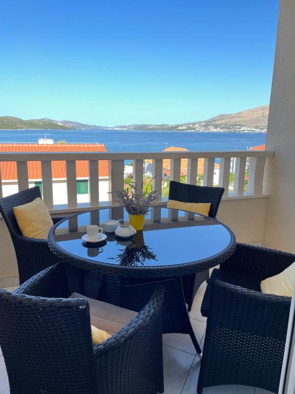 a table on a balcony with a view of the ocean at Apartment Ana in Trogir