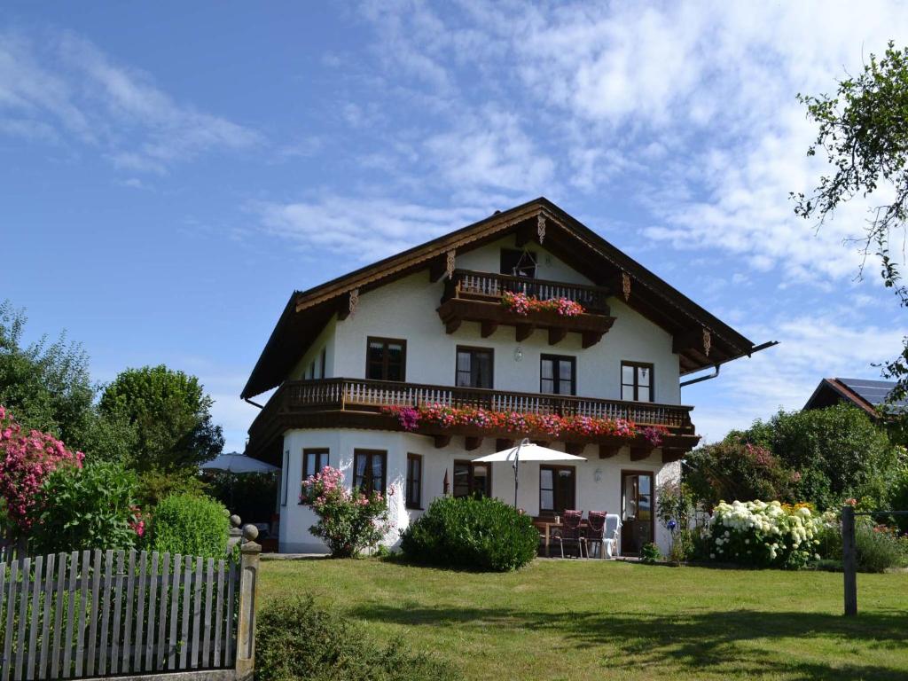 Una casa blanca con balcón y flores. en Pichler Roswitha en Bad Endorf