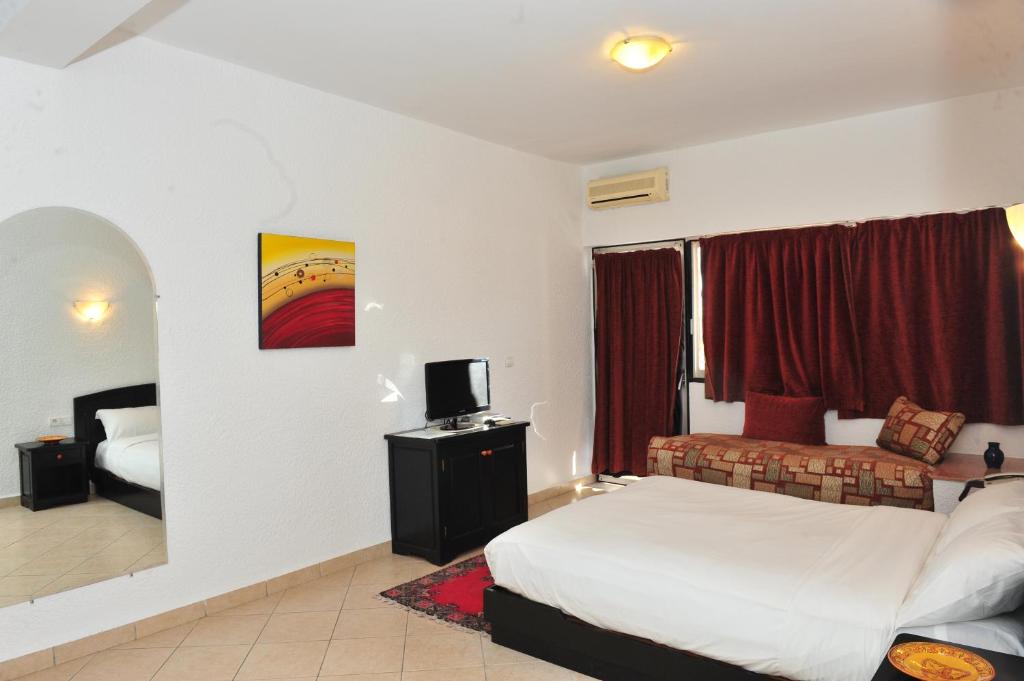 a hotel room with a bed and a tv in it at Studiotel Afoud in Agadir