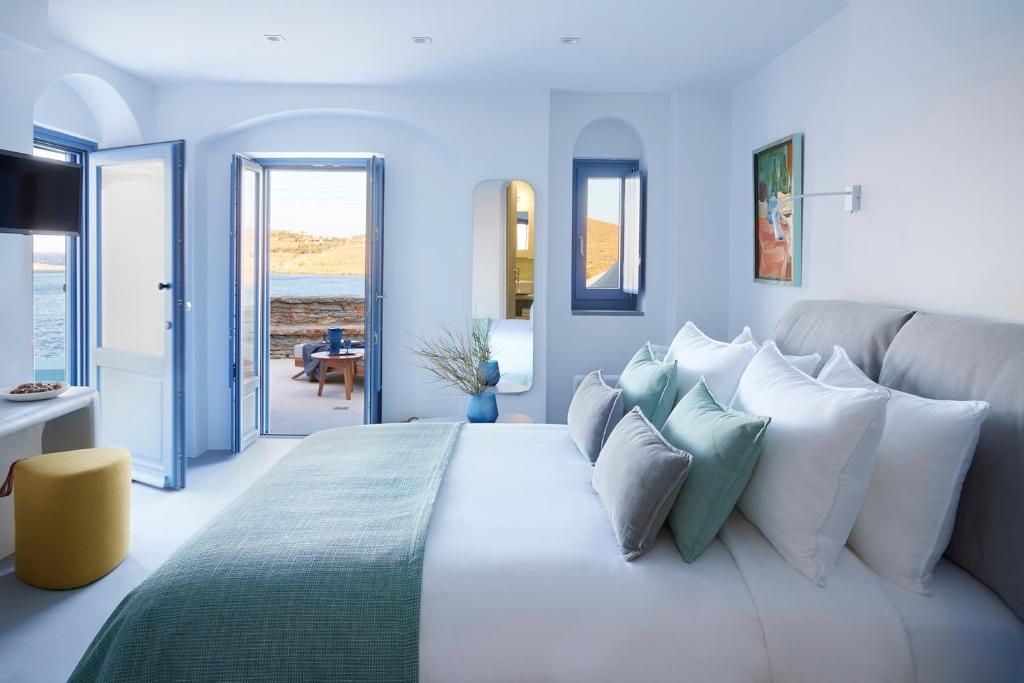 Kea Mare Luxury Villas في Vourkari: غرفة نوم بسرير كبير بجدران زرقاء