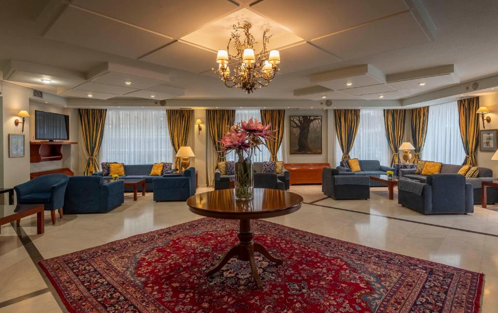 eine Lobby mit Sofas und einer Vase Blumen auf dem Tisch in der Unterkunft Hotel Kierion in Kardítsa