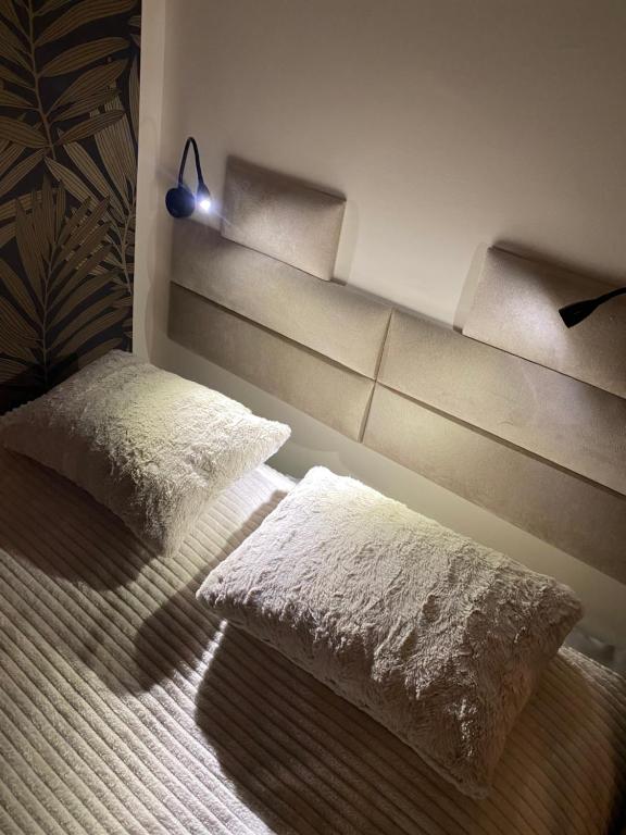 ein Zimmer mit zwei Kissen auf einem Bett mit einem Regal in der Unterkunft Apartament Szczecinek - Spokojna okolica in Szczecinek
