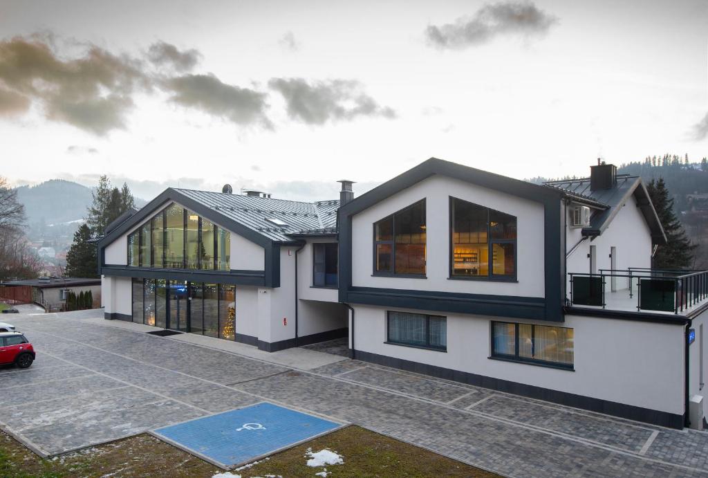 ein Haus mit einem davor geparkt in der Unterkunft Hotel Jarzębata in Wisła