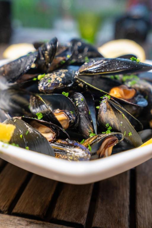 a plate of mussels on a wooden table at Agriturismo Buranco in Monterosso al Mare