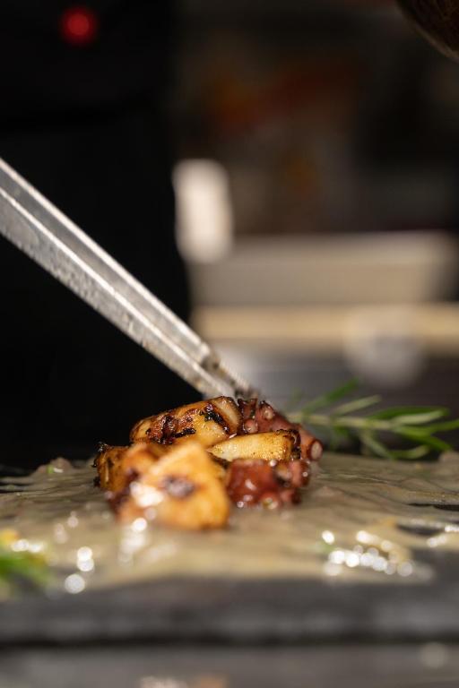 a pair of tongs cutting a piece of food at Agriturismo Buranco in Monterosso al Mare