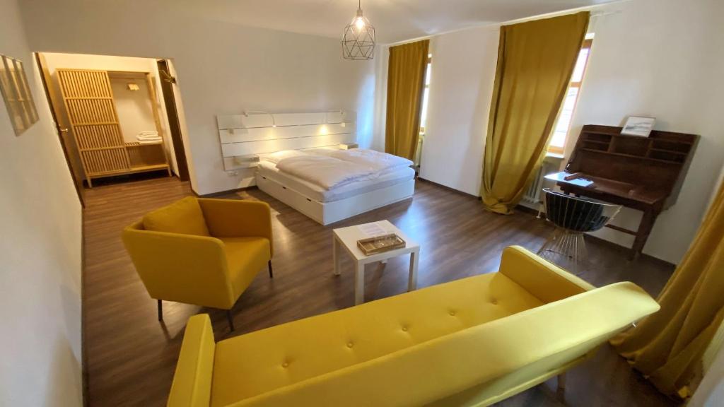 ein Wohnzimmer mit einem Sofa, einem Bett und einem Klavier in der Unterkunft Hotel Sonne in Wassertrüdingen