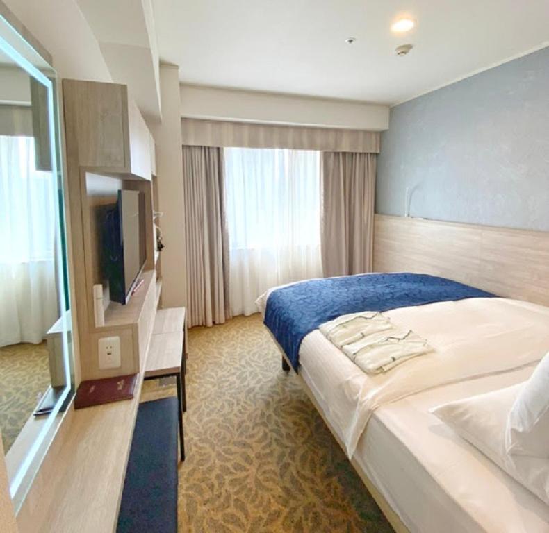 a hotel room with a bed and a television at Hotel Rose Garden Shinjuku in Tokyo