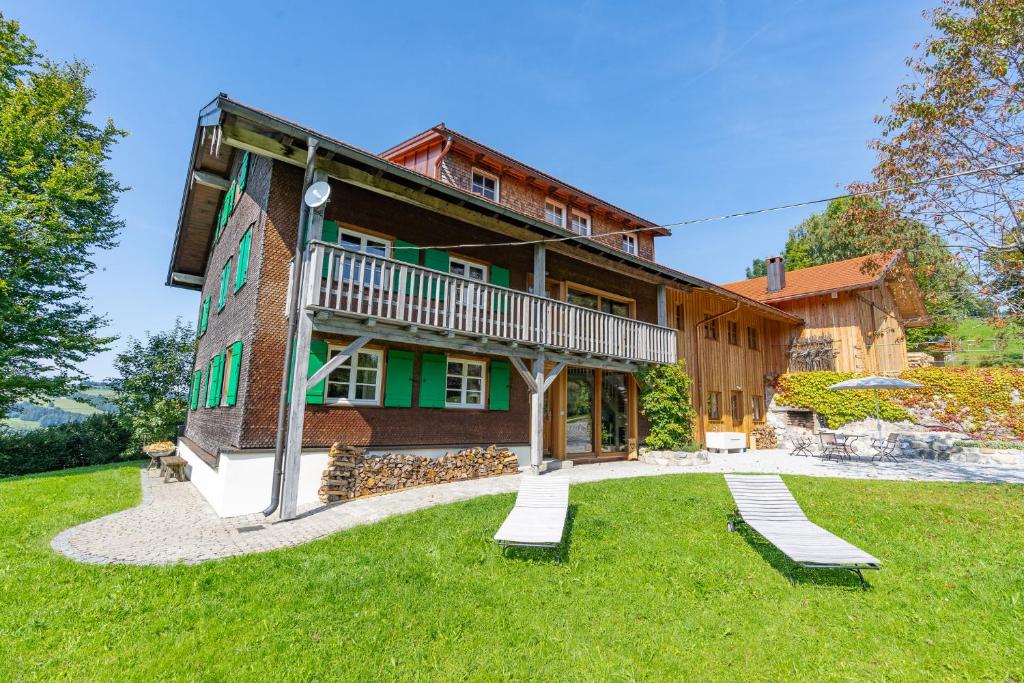 a house with two benches in front of it at Landhaus Buchenberg in Rettenberg