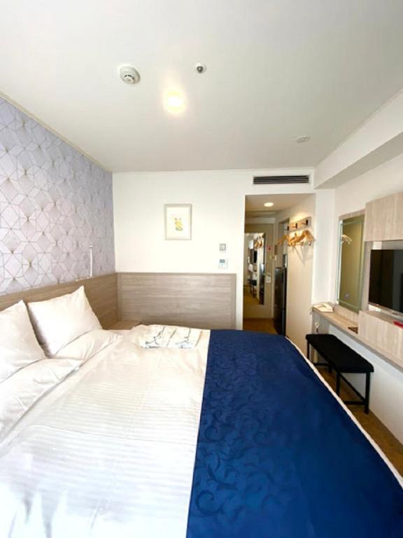 a bedroom with a large bed and a television at Hotel Rose Garden Shinjuku in Tokyo