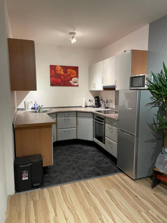 eine Küche mit weißen Schränken und Küchengeräten aus Edelstahl in der Unterkunft Apartment 22 in Kirchhain