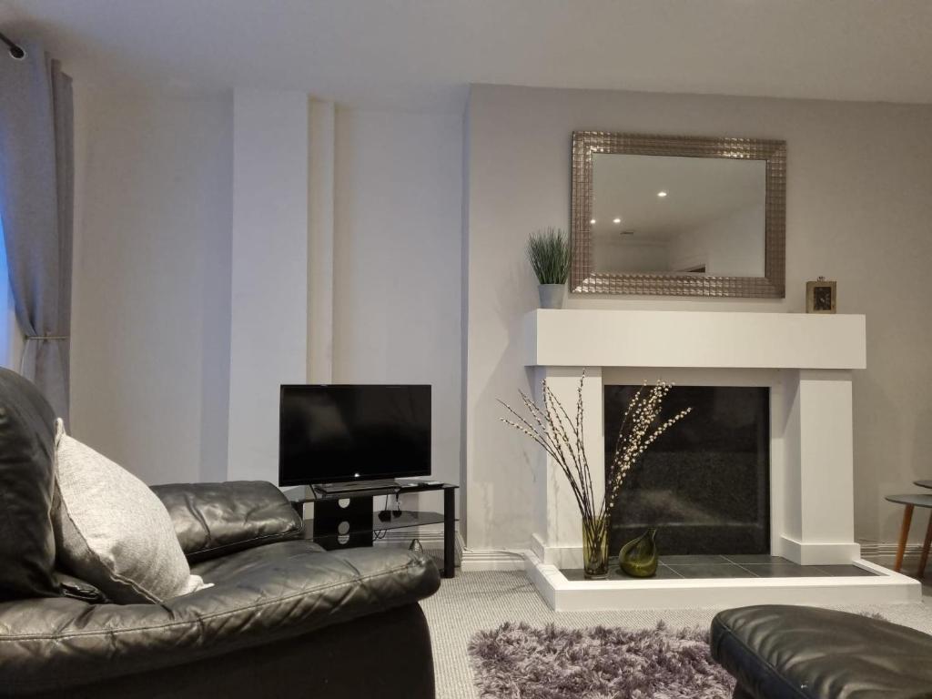 a living room with a couch and a fireplace at The Townhouse, Derry City Centre. in Derry Londonderry