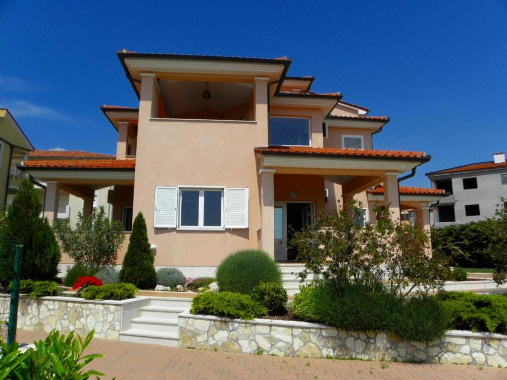 a house with a lot of plants in front of it at Apartment in Premantura with terrace, air conditioning, WiFi, washing machine 3352-27 in Premantura