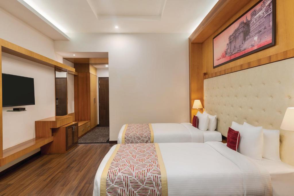 Postel nebo postele na pokoji v ubytování Ramada by Wyndham Varanasi Katesar
