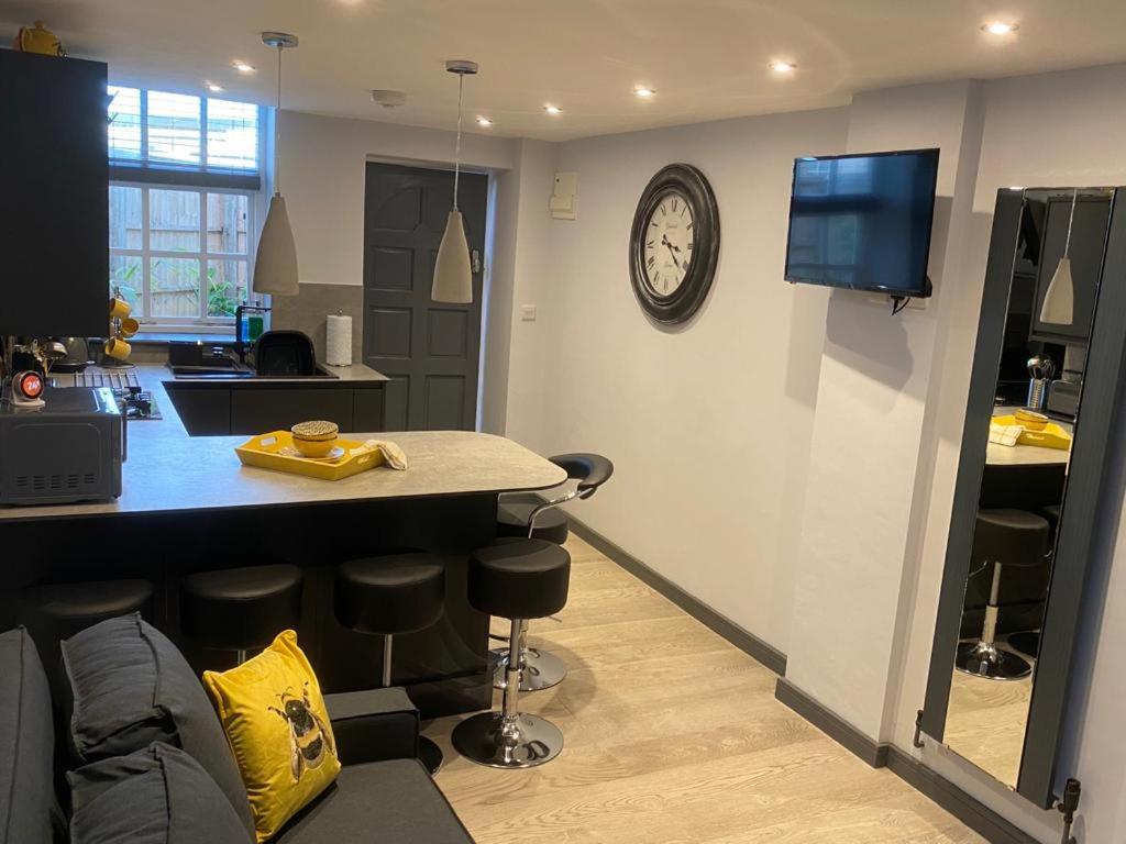 a kitchen with a counter and a tv on a wall at Top Tip Rooms Newmarket in Newmarket