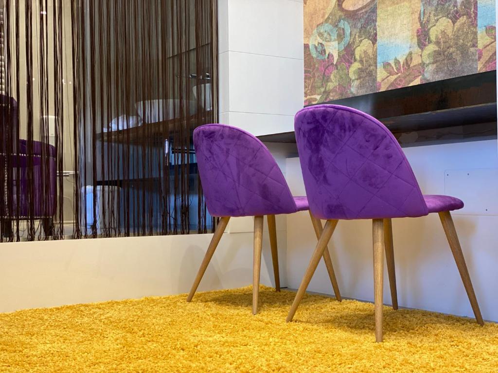 a pair of purple chairs sitting next to a table at Gran Paradiso Hotel Spa in San Giovanni Rotondo