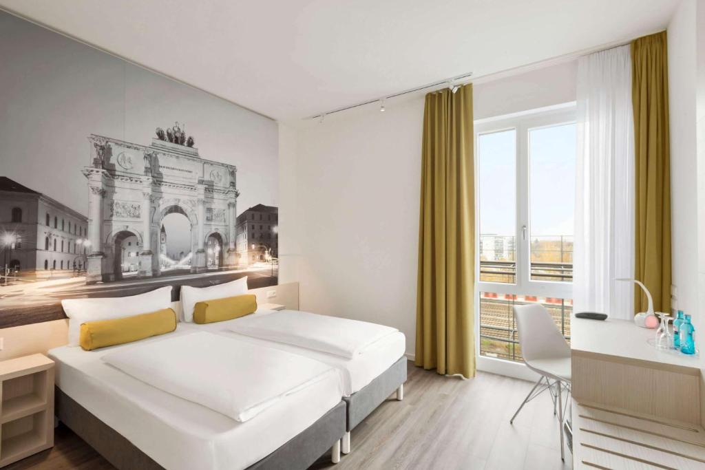 una camera da letto con un grande letto bianco e una grande finestra di Super 8 by Wyndham Munich City West a Monaco