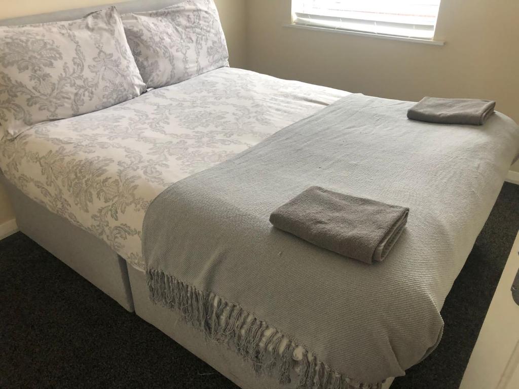 uma cama com duas toalhas em cima em Hinton House em Liverpool