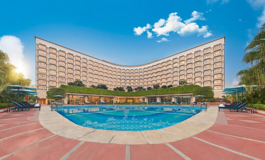 un hotel con una gran piscina frente a él en Taj Palace, New Delhi, en Nueva Delhi