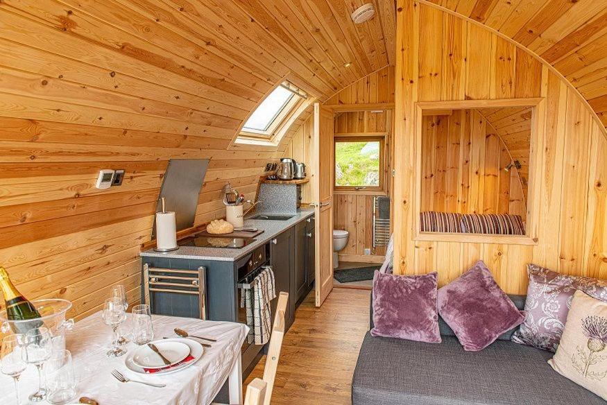 eine Küche mit einem Tisch und einem Herd in einer Hütte in der Unterkunft Beinn A Ghlo Luxury Glamping Pod with Hot Tub & Pet Friendly at Pitilie Pods in Aberfeldy