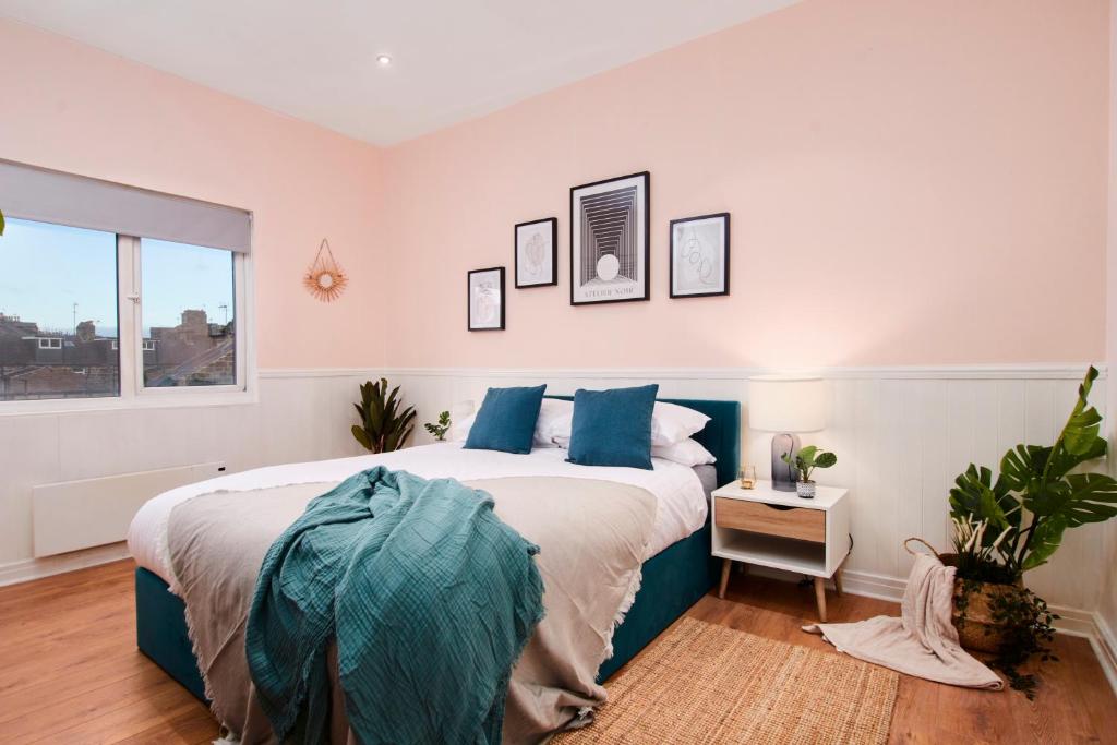ハロゲートにあるCentral Harrogate 2 Bedroom Apartmentのベッドルーム(青い枕の大型ベッド1台付)