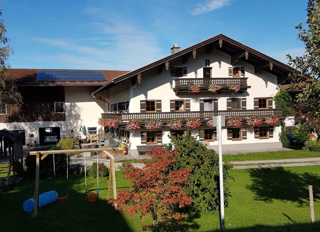 - un grand bâtiment blanc avec un panier de basket en face dans l'établissement Am Valtlhof, à Grabenstätt