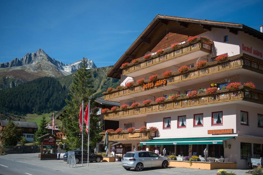 ein Hotel mit einem davor geparkt in der Unterkunft Hotel Mira in Sedrun