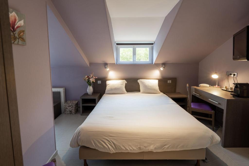 Voodi või voodid majutusasutuse Logis Central Hôtel - Restaurant & Spa toas