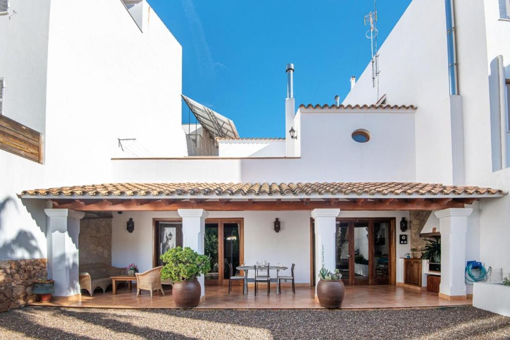 Casa blanca con patio con mesa y sillas en Ses Àmfores, en Ciutadella