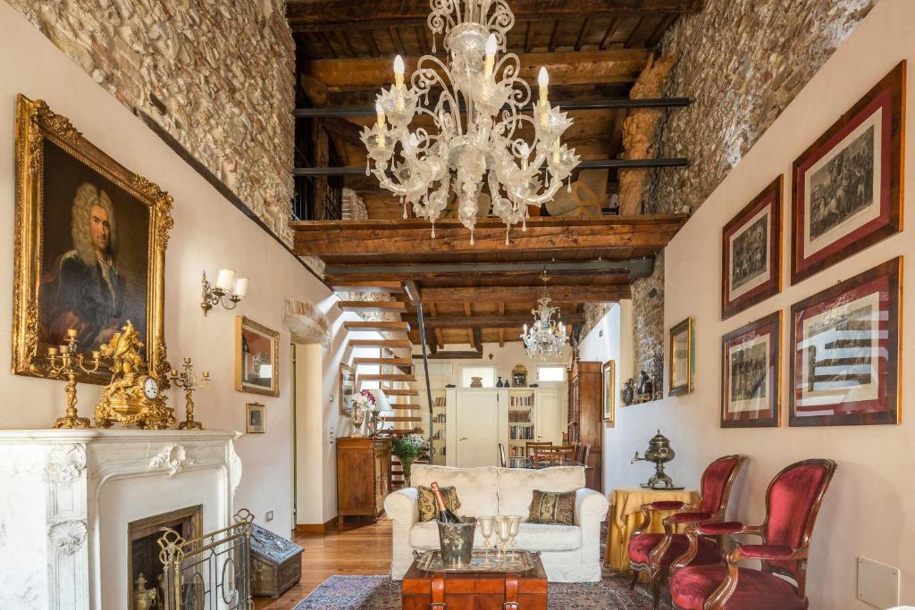 sala de estar con lámpara de araña y chimenea en Palazzo Benassi Penthouse, en Asolo