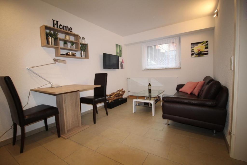 - un salon avec une table et un canapé dans l'établissement Gonsbach - Mikro-Apartment-26qm, à Mayence