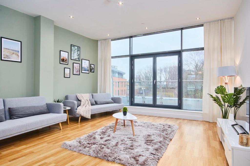 a living room with a couch and a table at Large Duplex Penthouse - Parking in Leeds