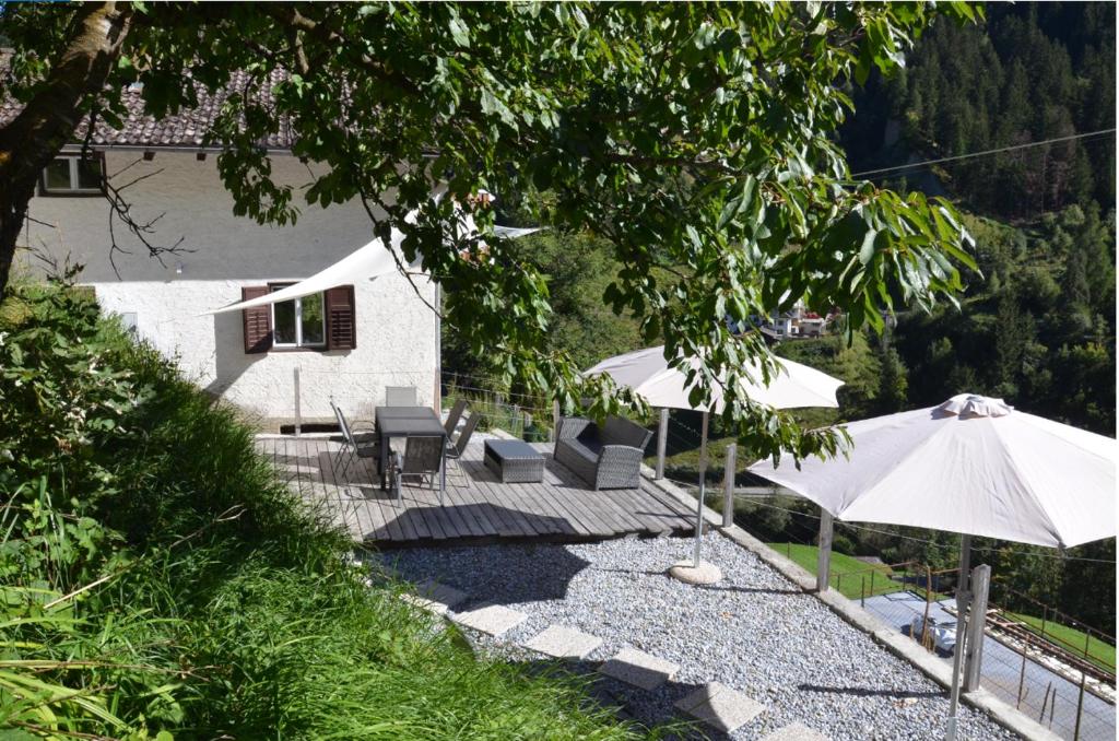 un patio con ombrelloni e sedie e una casa di Stilfser Häuschen mit Blick auf König Ortler a Stelvio