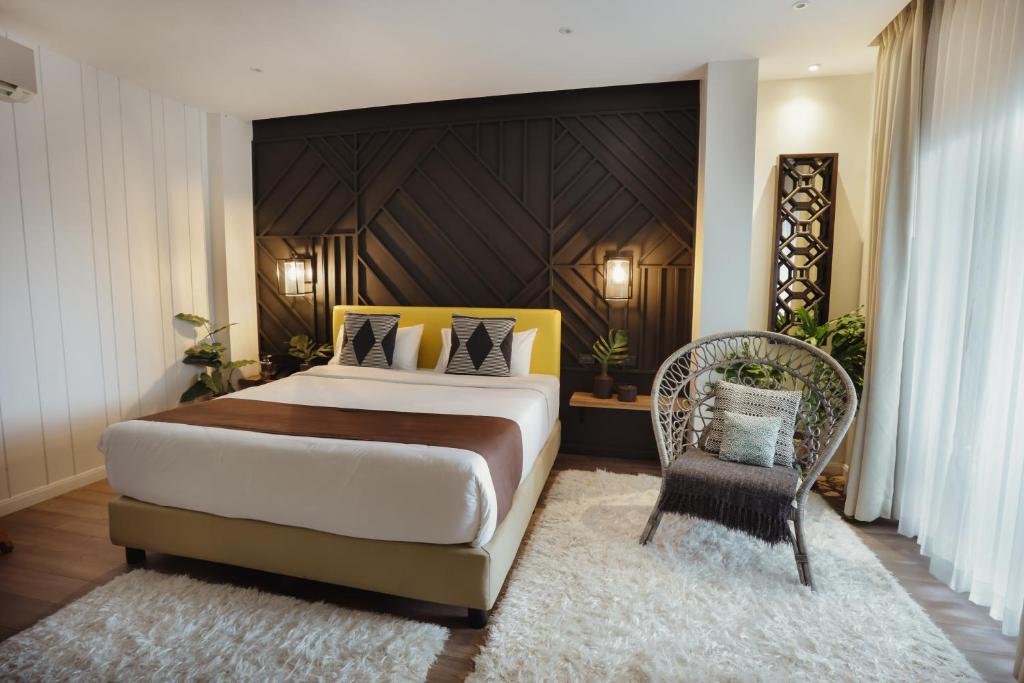 um quarto com uma cama grande e uma cadeira em The Bourke Hotel em Davao