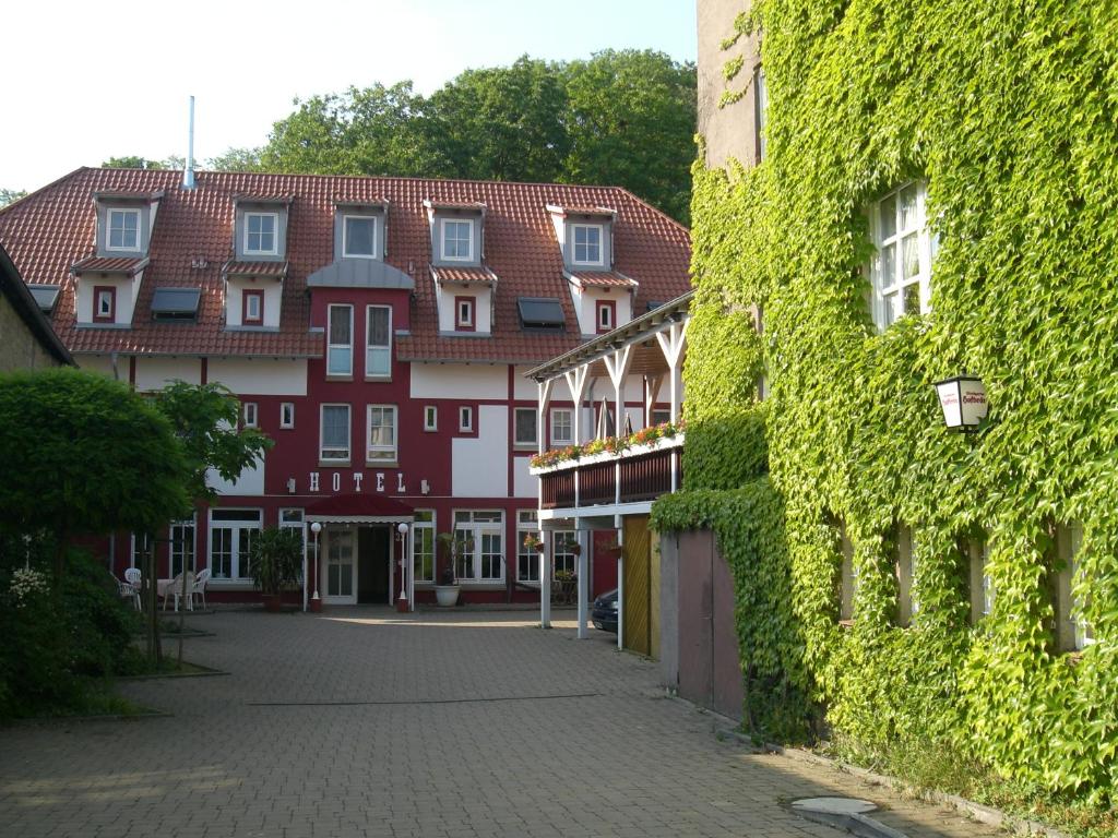 a cobblestone street next to a building with ivy at Cross-Country-Hotel Hirsch in Sinsheim
