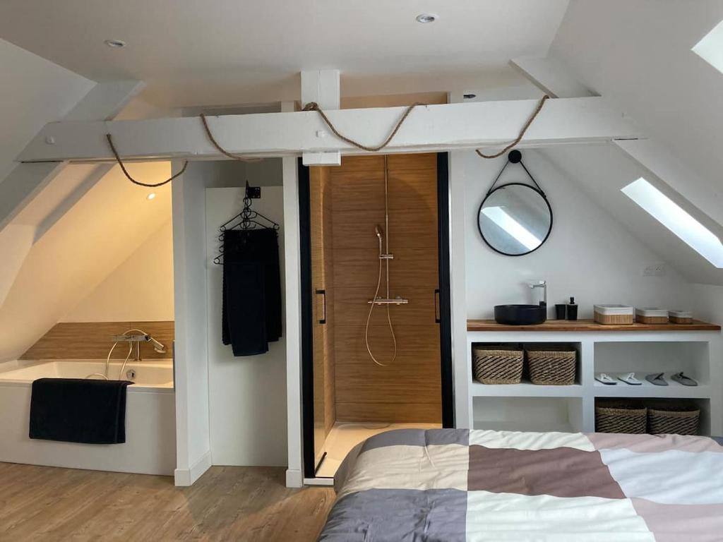 a bedroom with a bed and a bathroom with a sink at Appartement cosy en duplex à 50m de la plage in Le Portel