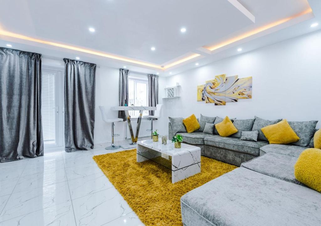 曼徹斯特的住宿－LUXURY 3 BEDROOM HOUSE Close to Manchester Center，客厅配有灰色的沙发和黄色的枕头。