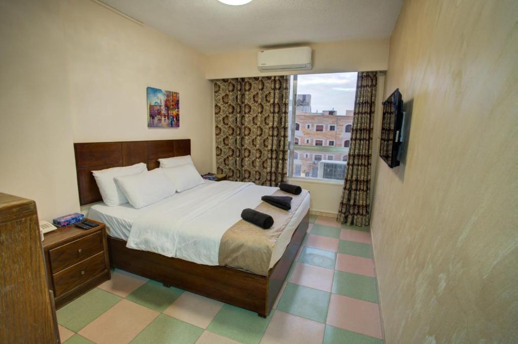 アカバにあるDarak hotelのベッドと窓が備わるホテルルーム
