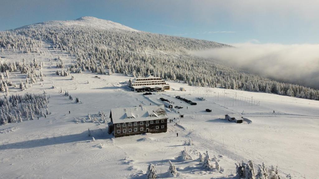 um alojamento de esqui no topo de uma montanha coberta de neve em Hotel Spindlerova Bouda em Špindlerŭv Mlýn