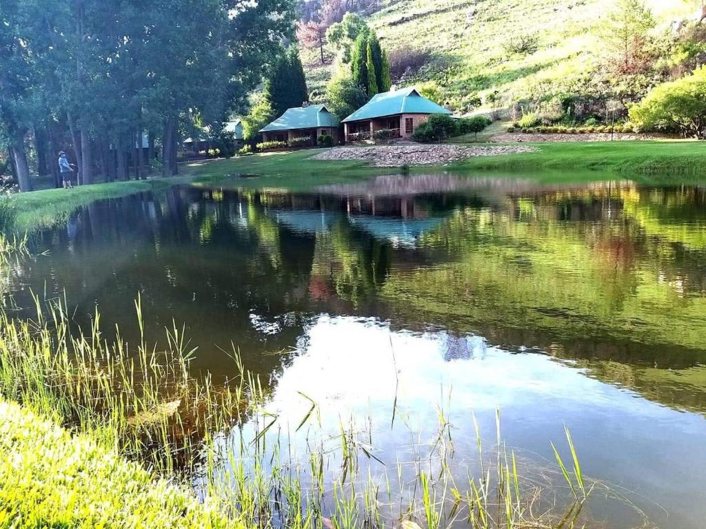 a lake with a gazebo next to a building at Trout River Falls in Lydenburg
