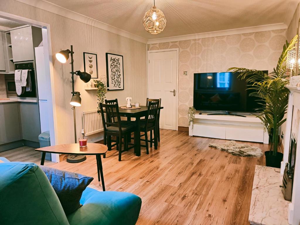 a living room with a couch and a tv and a table at City Centre Apartment- Beautiful Old Town- with Parking in Hull