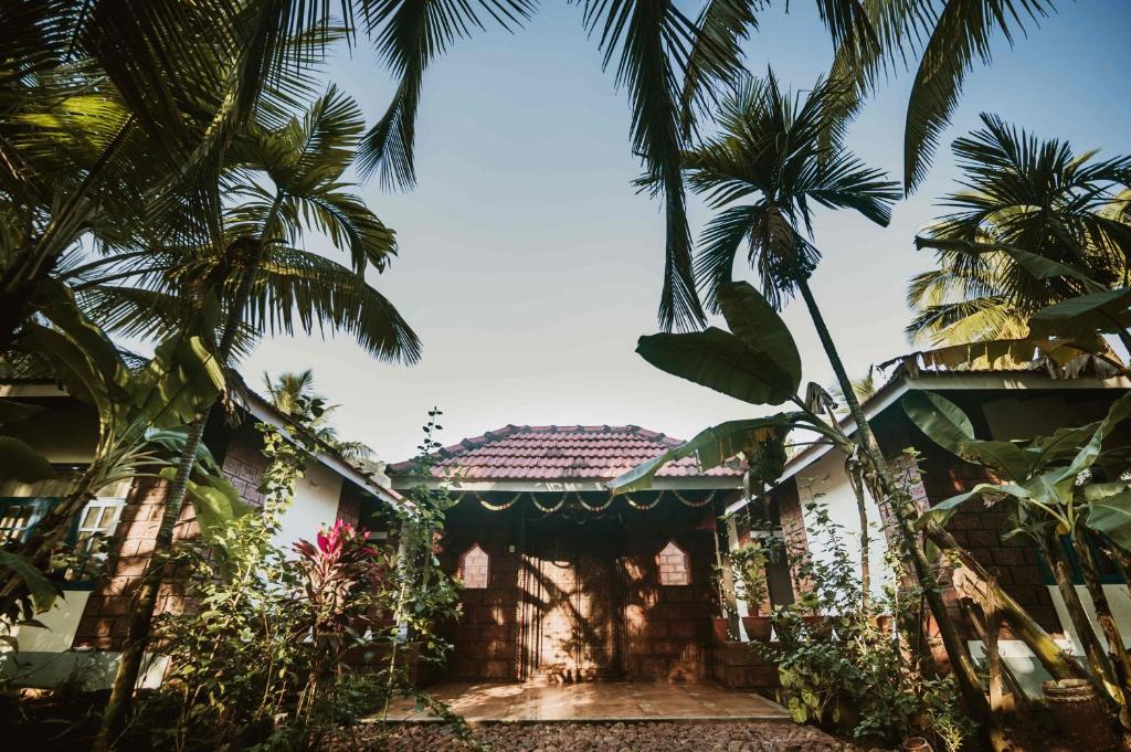 Dānde的住宿－Forest Casa By Rashmiraj - Kashid Beach，前面有棕榈树的房子