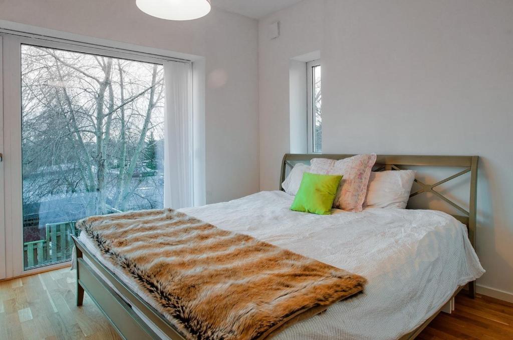 a bed in a bedroom with a large window at townhouse on Arlanda Stockholm metro line - easy checkin in Sollentuna