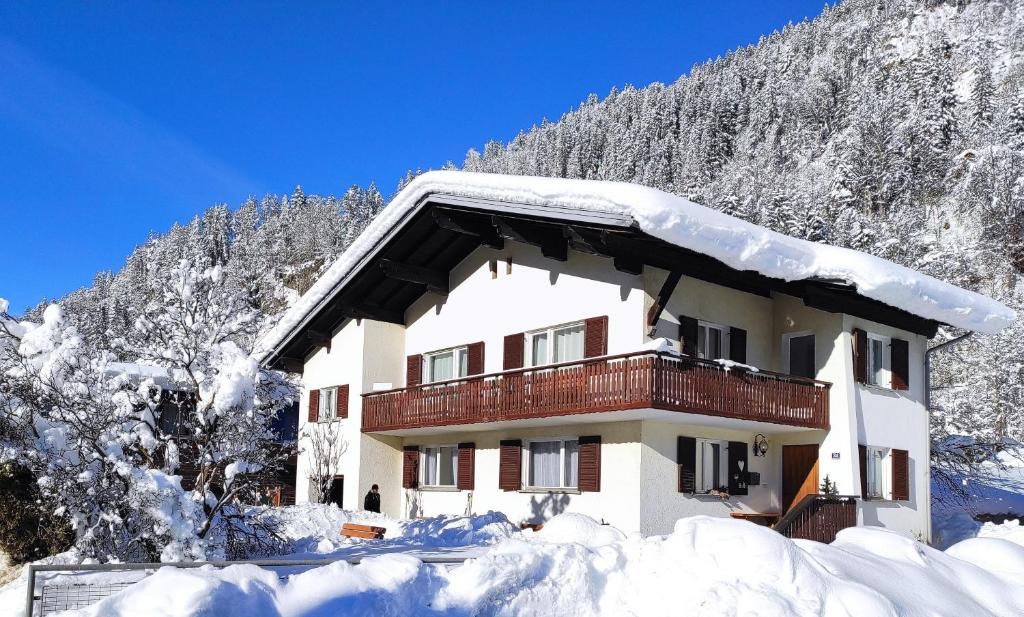 a snow covered building with a balcony in front of a mountain at Ferienhaus Sarah in Schruns-Tschagguns