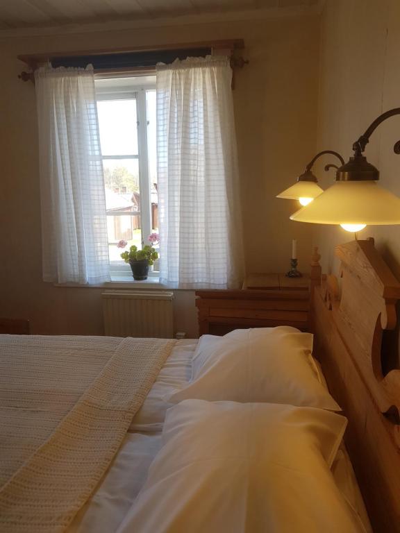 a bedroom with a large bed with a window at Lövånger Kyrkstad in Lövånger
