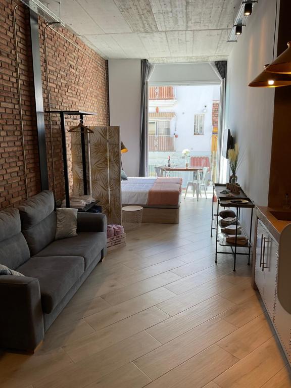 sala de estar con sofá y cama en VARELA 30 Apartamentos, en Málaga