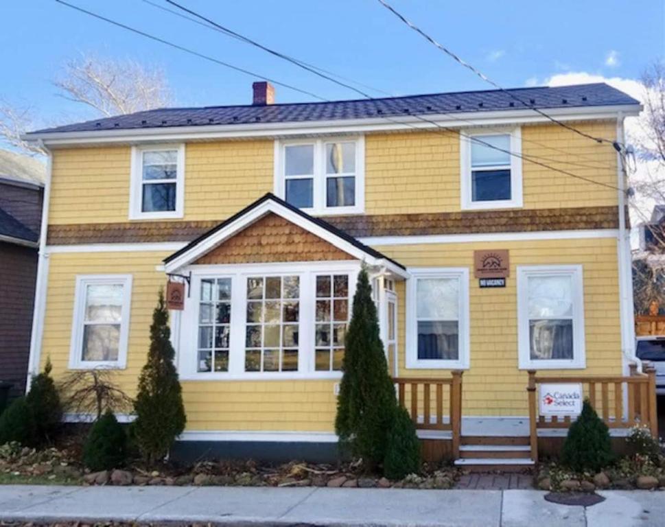 żółty dom z białymi oknami w obiekcie Sunny Home B&B w mieście Charlottetown