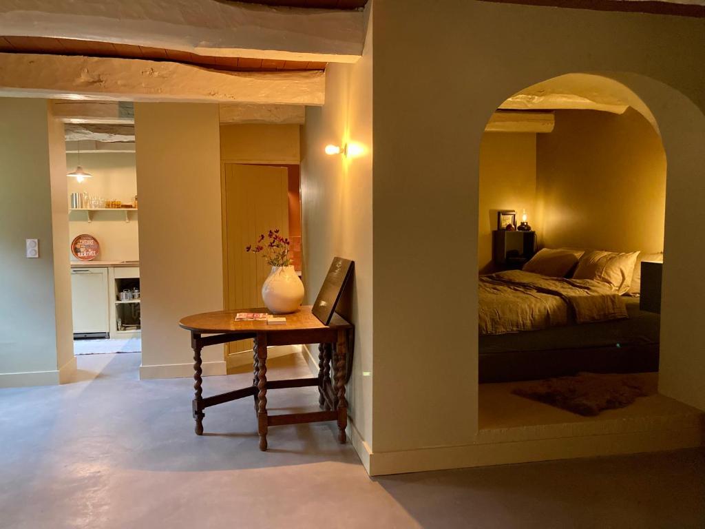 - une chambre avec un lit et une table avec un vase dans l'établissement Encore une fois, Entre deux, à Locmalo