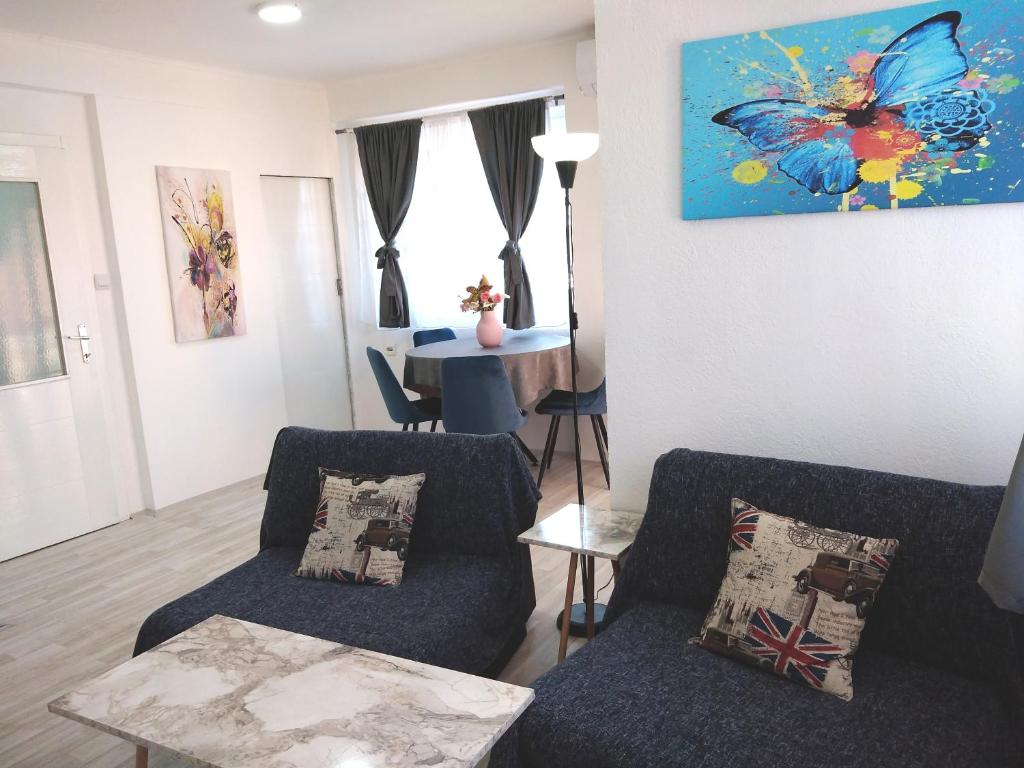 a living room with two chairs and a table at Happiness Apartment Center in Bitola