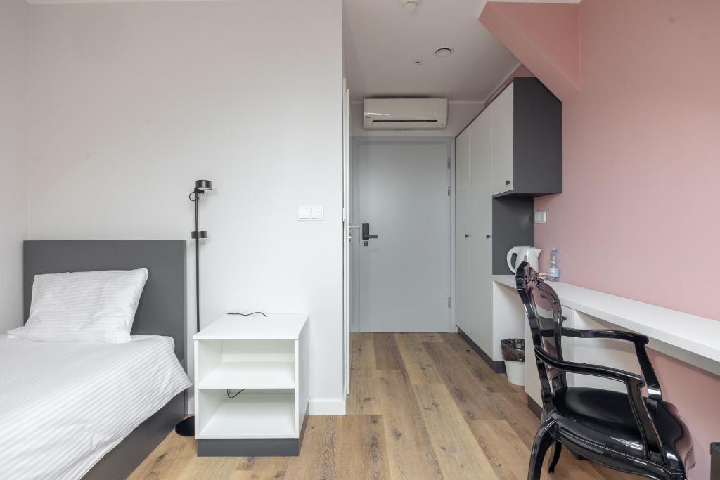 een slaapkamer met een bed, een bureau en een stoel bij ĄĘ Hostel Nowy Świat in Warschau